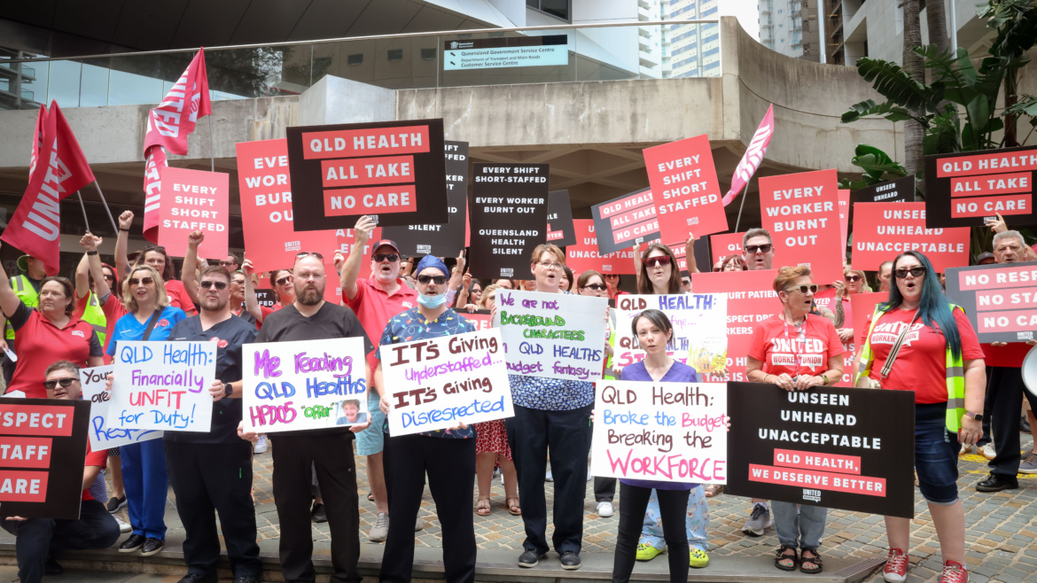 A group of health workers and UWU members protesting outside a building.